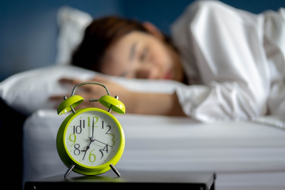 Female sleeping with alarm clock on her side